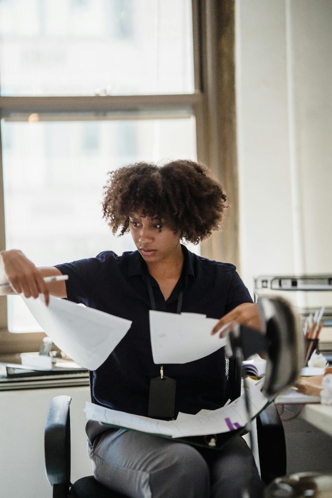 Professionele vrouw die certificaten en documenten controleert aan een bureau